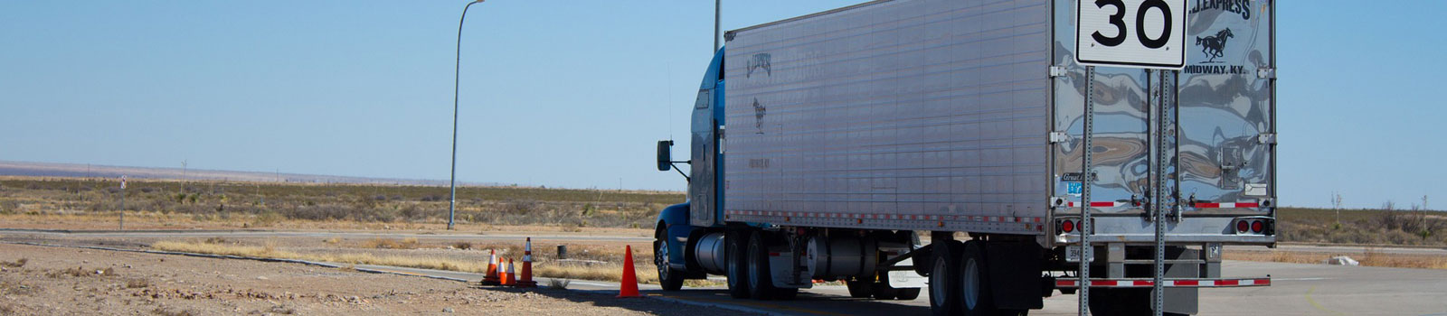 truck and driver resting on side of highway